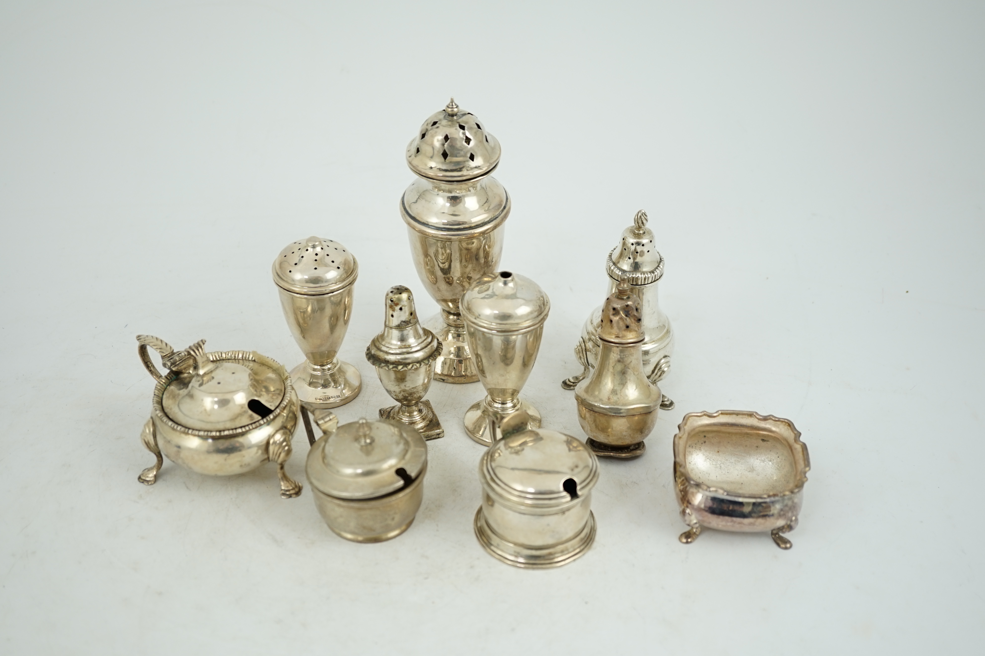 Nine assorted early 20th century and later silver condiments, various dates and makers and one plated condiment.